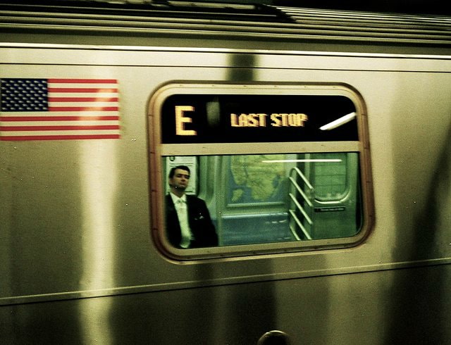 Photographed on 100 speed, Kodak film with my Hi-Matic rangefinder camera. As we know, 100 speed film can be a fine grain film & it can require a lot of light or a long exposure time with a precise aperture setting. In this frame, the platform's light from the subway station helped out immensely with a decent frame here. I did not use a flash with this frame. It was captured instinctively, as I viewed this gentleman asleep or closing his eyes as I was walking. The LAST STOP from the E train's sign, the American flag, the map next to him, the entire image of a frame within a frame (looking through the train's window) serves such a New York vibe. Long days for a City that does not sleep, so the LAST STOP can be a sign of relief or refuelling.